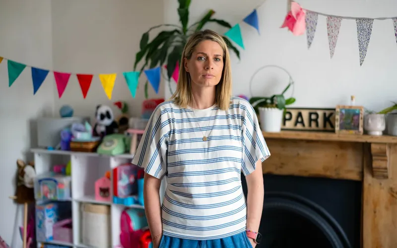 Dr Eli Prior standing in a room decorated with bunting.