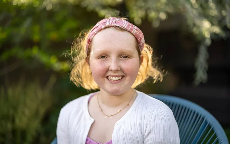 Kirsty Waugh smiling in a garden, wearing a pink headband.