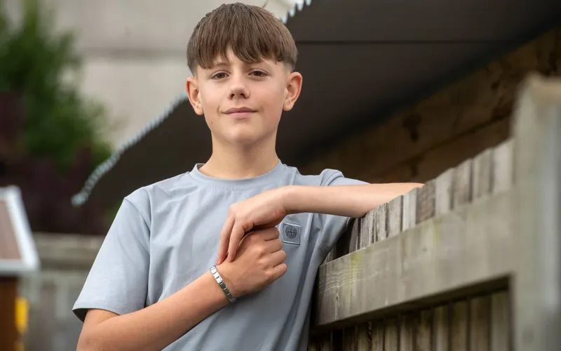 Zac Howells leaning on a wooden fence.